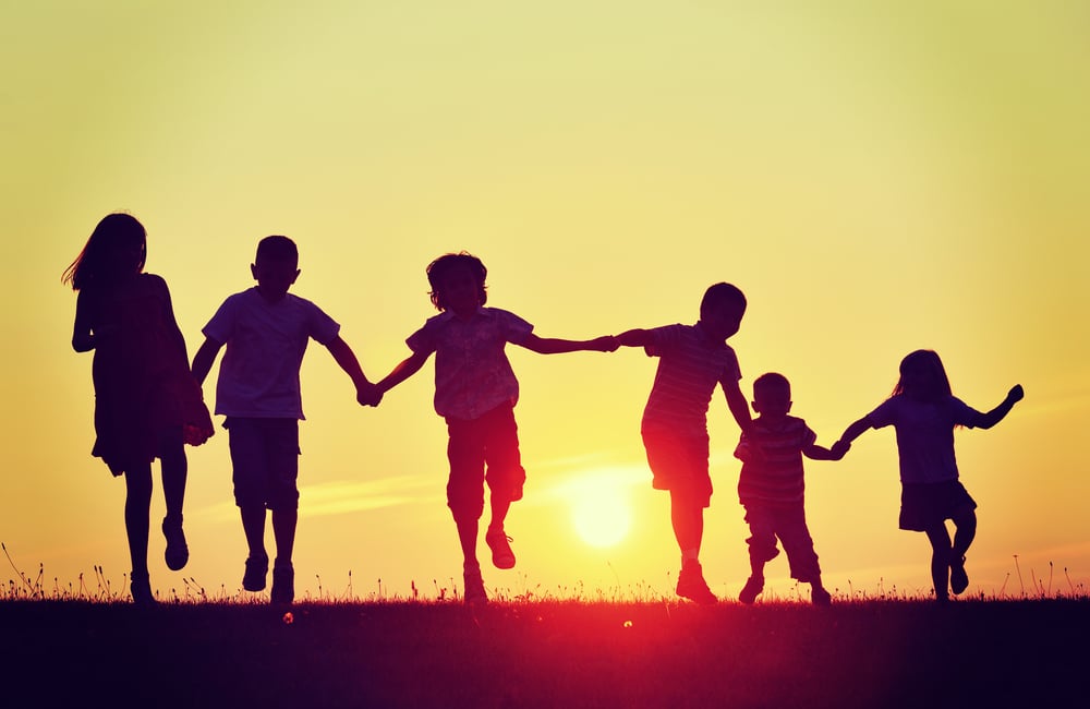 Happy children silhouettes on summer meadow running and jumping-1