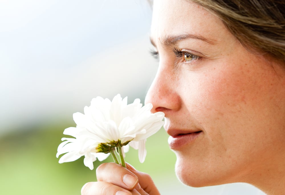 Portrait of a beautiful woman smelling a flower